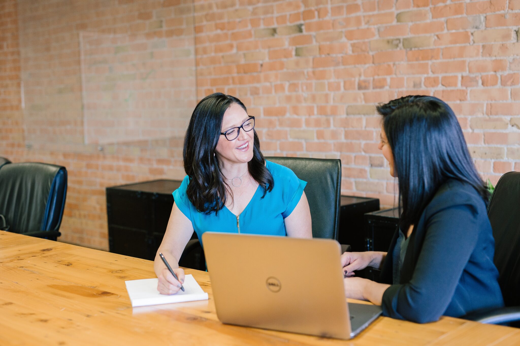 Duas mulheres de negócios em um escritório discutindo sobre serviços de secretariado corporativo no Chile.  