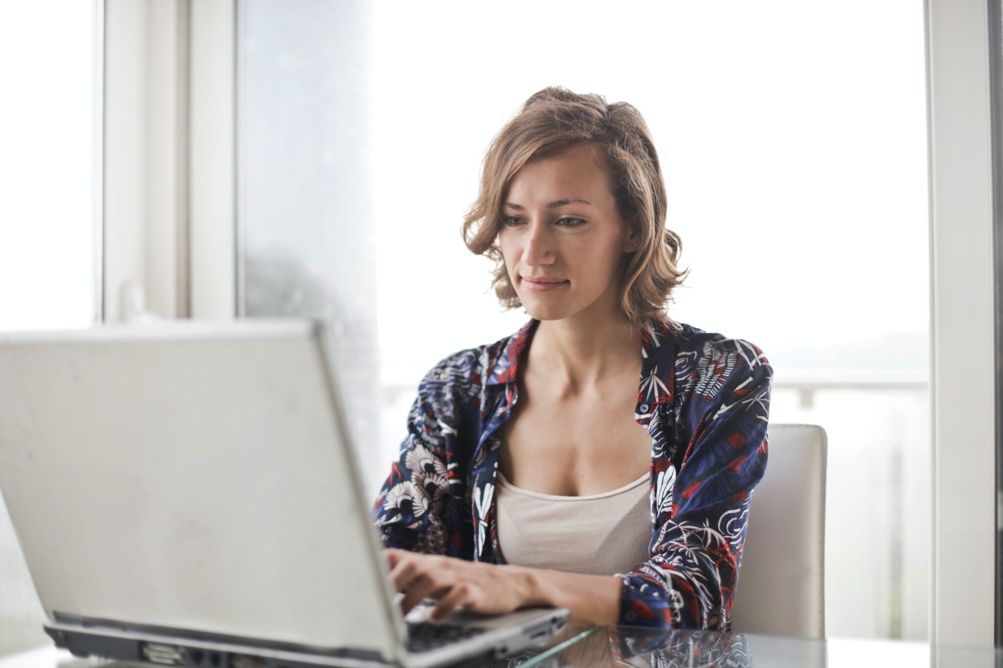 Mulher em casa usando seu computador para pesquisar informações sobre os desafios de fazer negócios no México.  