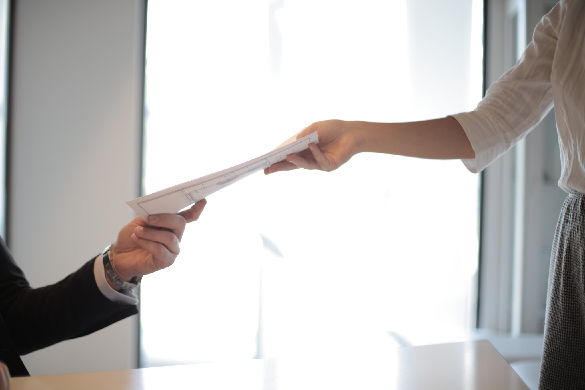 Mujer entregando a un hombre un documento sobre requisitos de facturación para una empresa extranjera en Paraguay  