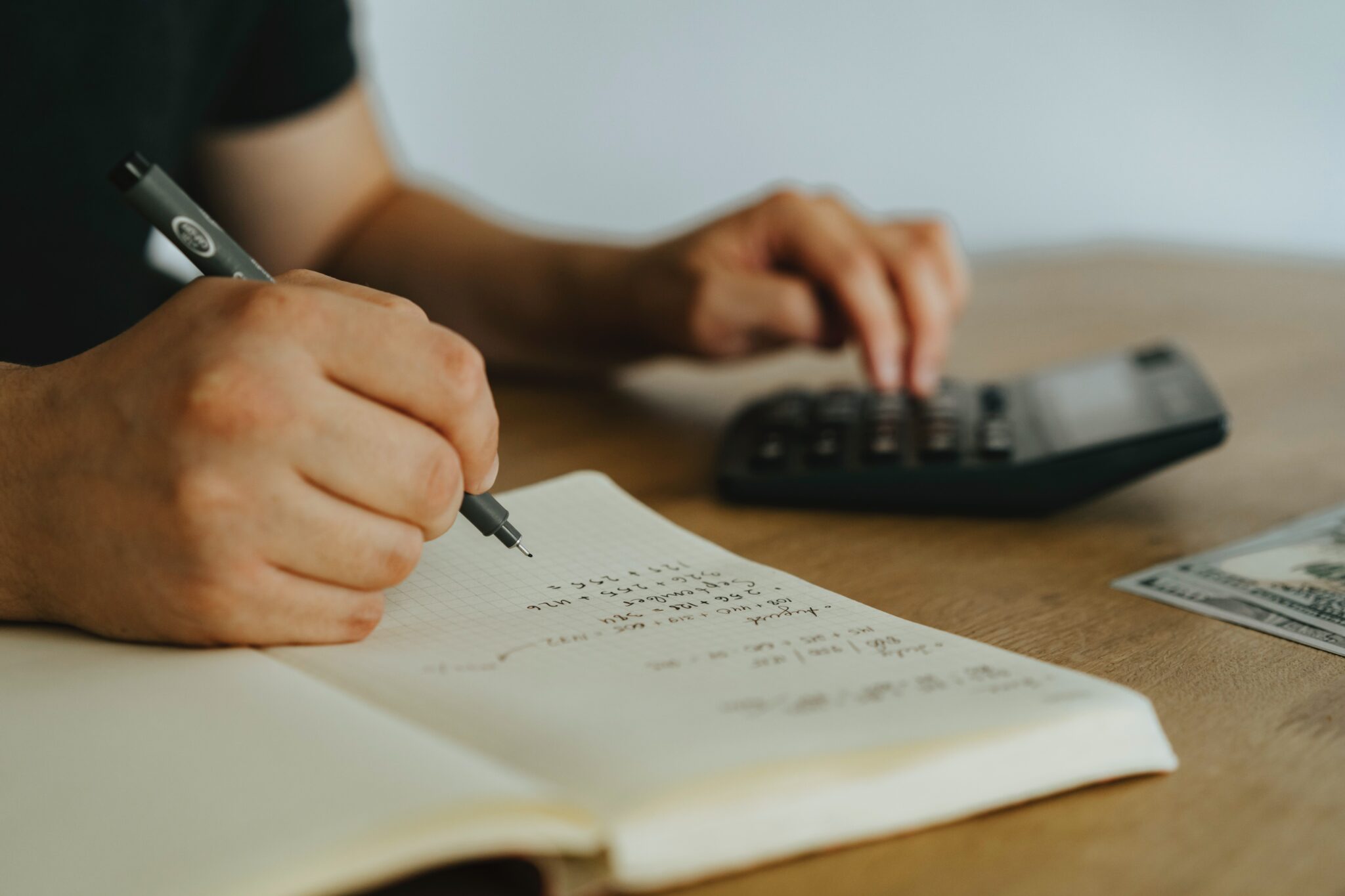 Homem usando uma calculadora para descobrir quanto dinheiro ele precisa pagar de impostos ao fazer negócios no Paraguai  