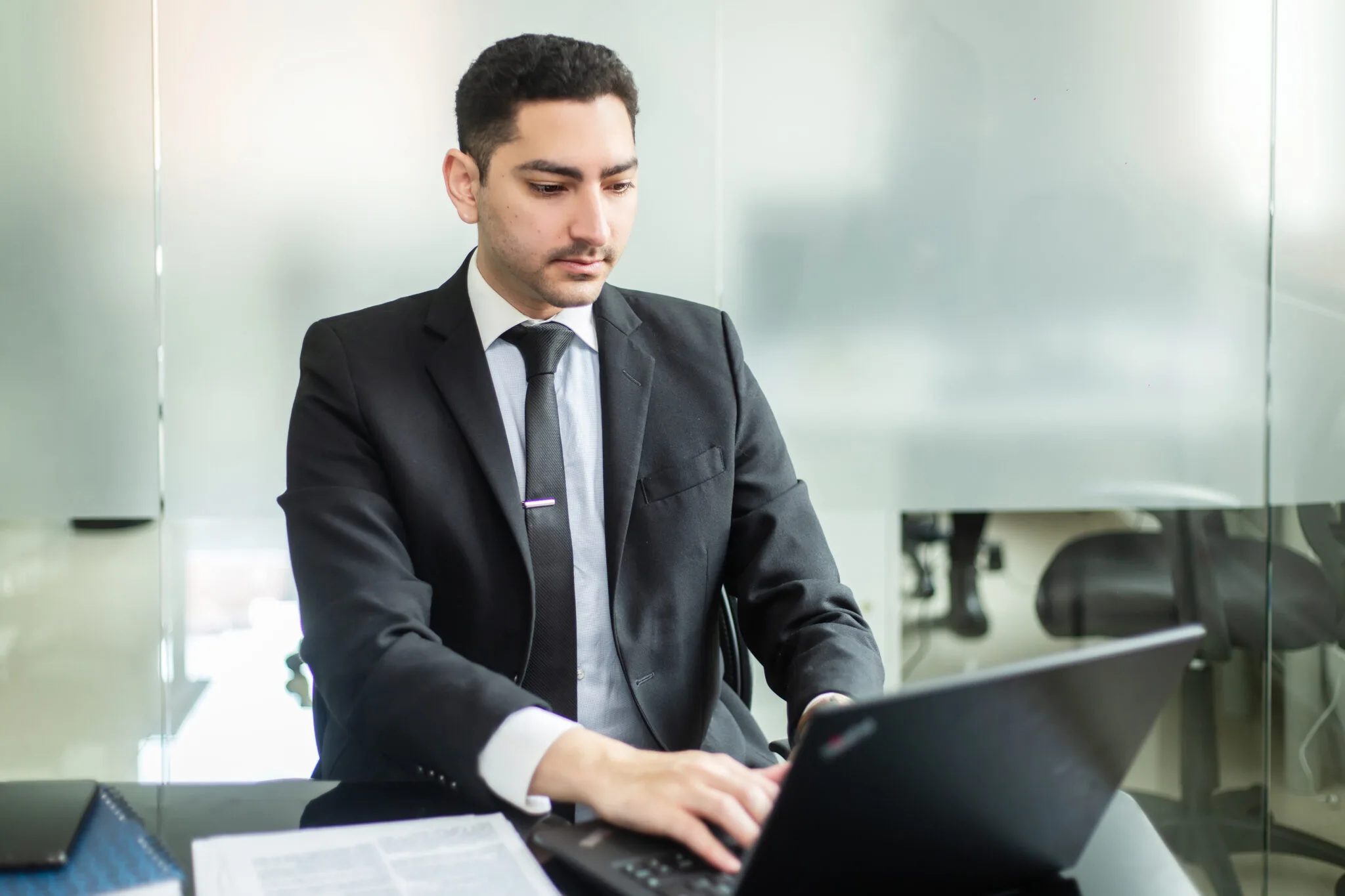 Hombre de negocios utilizando un ordenador portátil, representando a un hombre buscando información sobre servicios de back office en Panamá. 