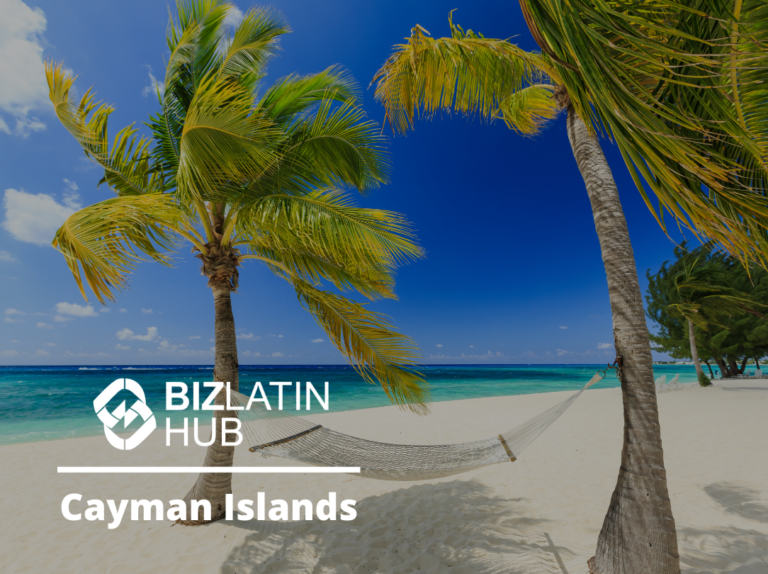 A serene tropical beach scene in the Cayman Islands featuring a hammock strung between two palm trees on white sand under a blue sky with scattered clouds. The crystal-clear ocean is in the background. The BizLatin Hub logo and text highlight "Requisitos de contabilidade e tributação empresarial nas Ilhas Cayman.