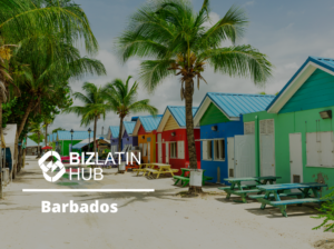 A row of colorful beach houses are lined up along a sandy path under clear skies and palm trees. The Biz Latin Hub logo and the phrase "Register a Company in Barbados" are displayed on the left side of the image. Picnic tables are placed outside each house.