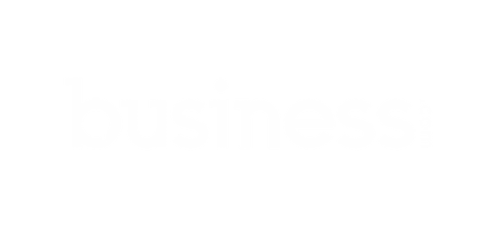 The image shows the logo of business.com. The logo features the word "business" in all lowercase letters, with ".com" written vertically next to the letter "s". The text, often associated with fields like recruitment and accounting, is white on a transparent background.